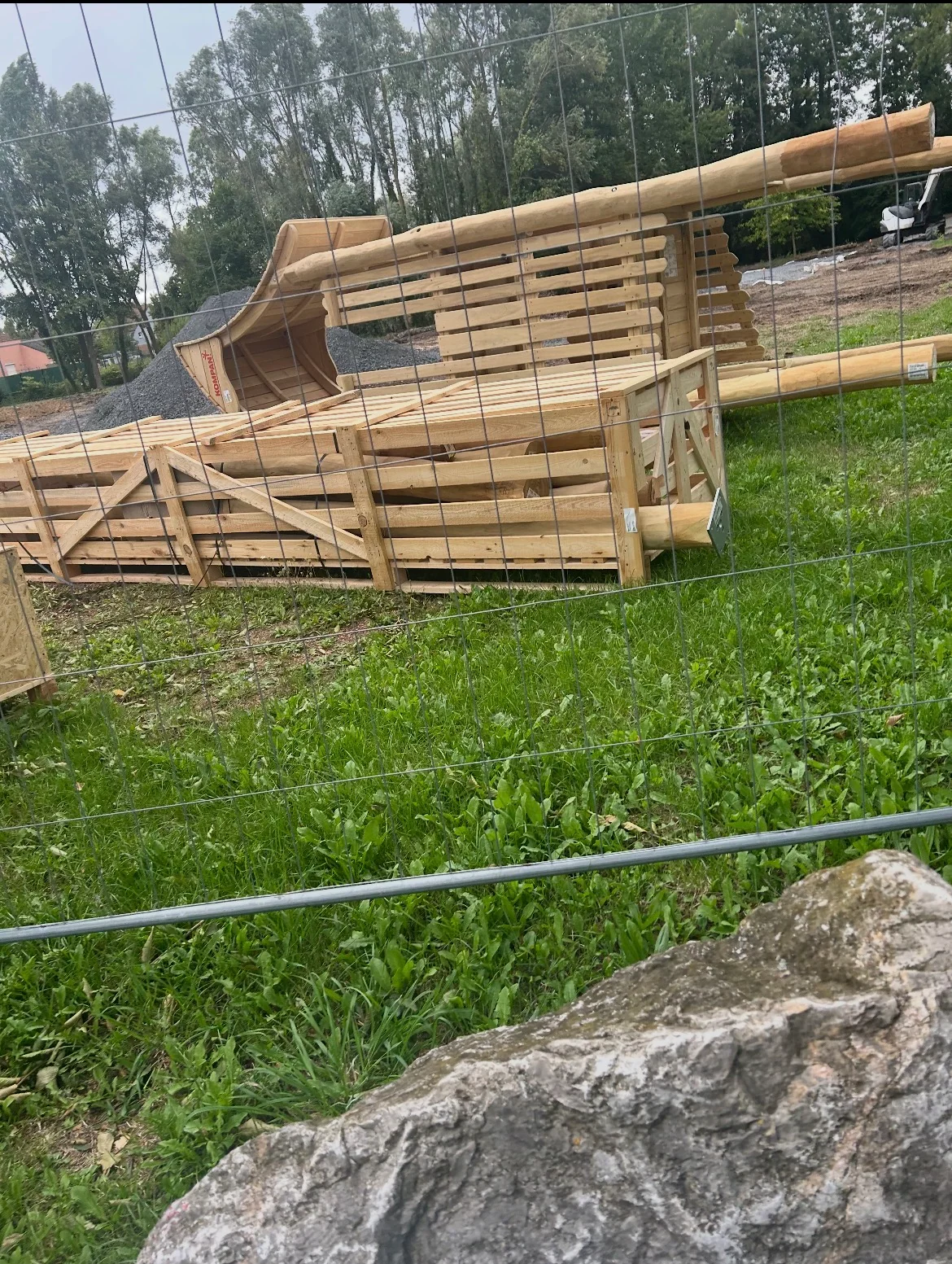 Éléments en bois stockés derrière les barrières du chantier