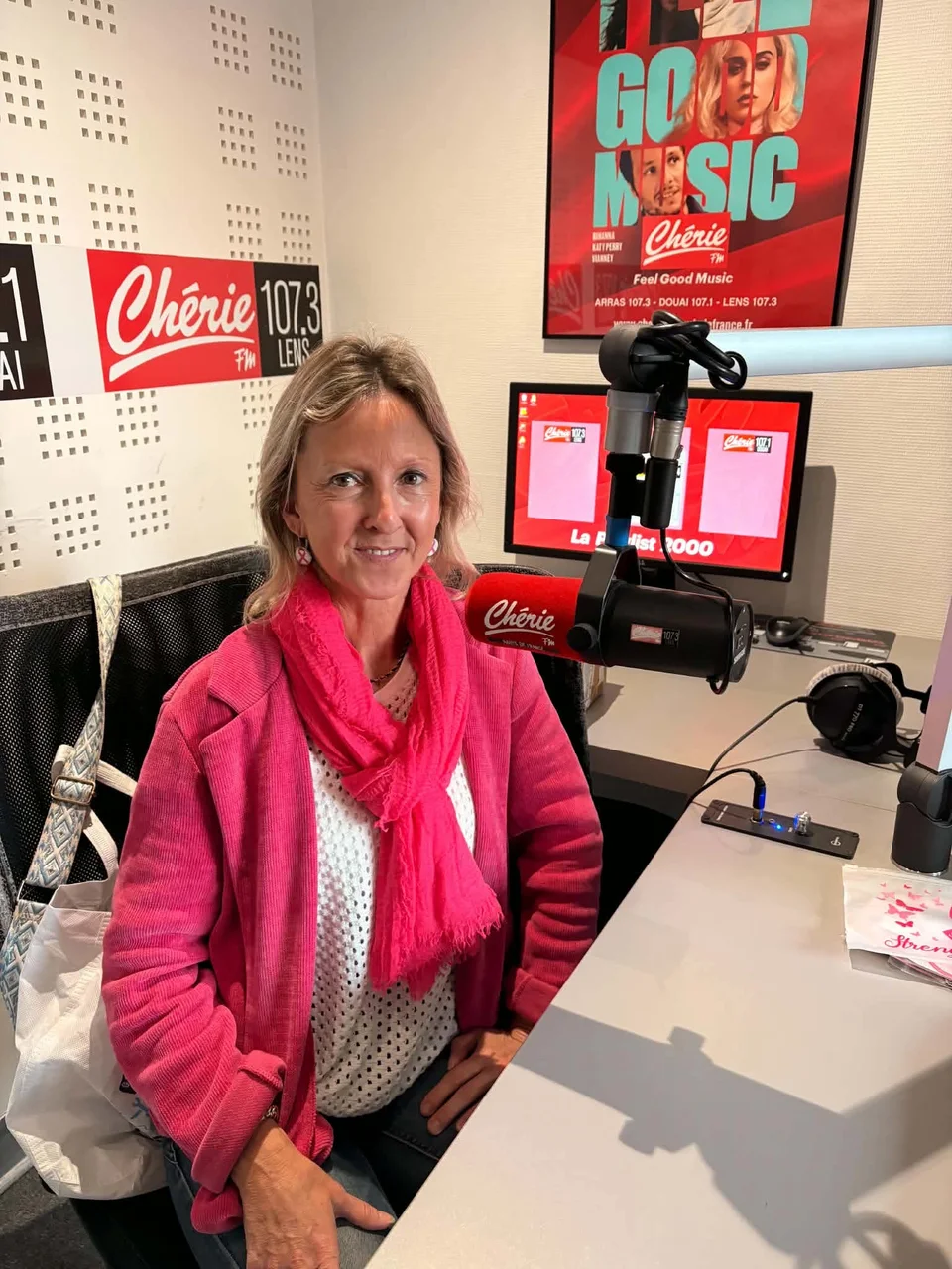 Joëlle Louvet, organisatrice du cortège moto Octobre Rose à Douai, assise devant un microphone dans un studio de Chérie FM.